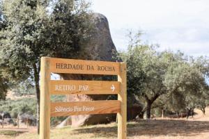 a sign in the middle of a field with trees at Herdade da Rocha - Boutique Lodge in Crato
