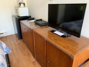 a large flat screen tv sitting on top of a wooden entertainment center at Motel Giffard in Quebec City