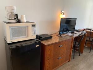 eine Küche mit einer Mikrowelle und einer Theke mit einem Kühlschrank in der Unterkunft Motel Giffard in Québec