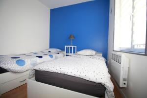 a bedroom with two twin beds and a blue wall at Santorini in La Fère