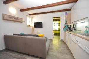 a living room with a couch and a kitchen at New Lux Apartman Kala in Poreč