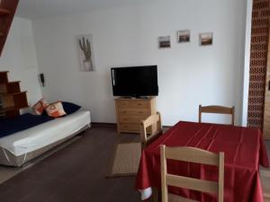 a living room with a table and a tv and a bed at da GIUSEPPE in Tuttlingen
