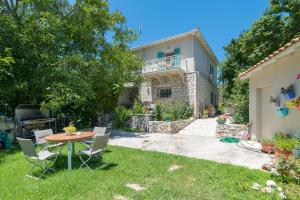 um jardim com mesa e cadeiras em frente a uma casa em Avelia Blue em Asprogerakata