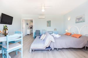 ein blau-weißes Schlafzimmer mit einem Bett und einem Schreibtisch in der Unterkunft Mariners (3) - Bright and stylish apartment - 2 minute walk to the beach in Luz
