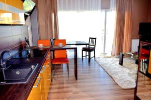 a kitchen and dining room with a table and orange chairs at Apartament Sianożęty in Sianozety