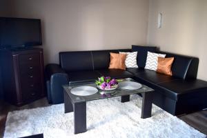 a living room with a black couch and a table at Apartament Sianożęty in Sianozety
