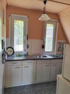 a kitchen with a sink and two windows at Ferienhaus am Helenesee 1 in Frankfurt Oder +11 photos