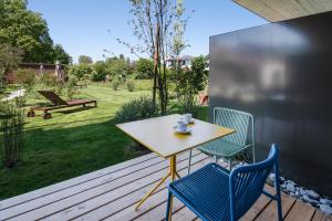 a table and two chairs on a wooden deck at Sternen Bohlingen Aparthotel in Singen