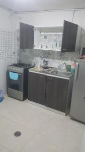 a kitchen with a stove and a sink and a refrigerator at Cerca al club militar embajada americana, Corferias 502 in Bogotá