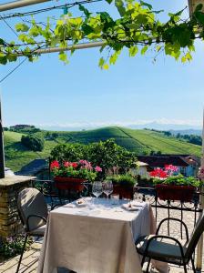 a table with wine glasses and a view of a vineyard at Locanda Rabaya' in Barbaresco