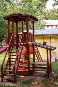 a wooden play structure with a slide and a playground at Бунгала Камена - Bungalows Kamena in Kamena