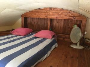 een slaapkamer met een bed met 2 roze kussens bij Repaire de Barberousse de Gruissan in Gruissan