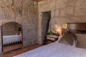 a bedroom with a bed in a stone wall at Casa dos Muiños in Pontevedra