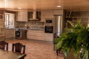 una cocina con electrodomésticos de acero inoxidable, mesa y sillas en Casa dos Muiños, en Pontevedra
