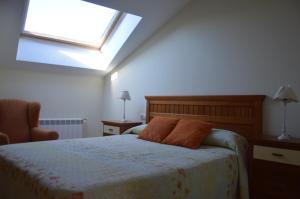 Dormitorio con cama con almohada naranja en Apartamento El Collau, en Posada de Llanes