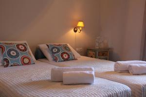 Un dormitorio con dos camas con toallas encima. en Eleas gi (Olive Grove Estate), en Tsilivi