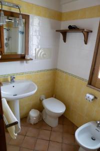 a bathroom with a toilet, sink, and mirror at Borgo San Francesco in Gioiosa Marea