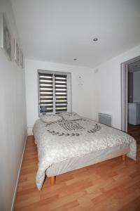 1 dormitorio con 1 cama grande en una habitación blanca en la fere du siècle, en La Fère