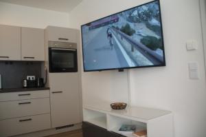 a flat screen tv hanging on a wall in a kitchen at Kirschbluetenappartements in Breitenbrunn