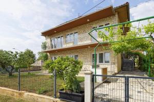 a brick house with a fence in front of it at Apartment Patrik by Rent Istria in Umag