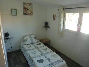 a small bedroom with a bed and a window at Mas Provençal in Le Lavandou