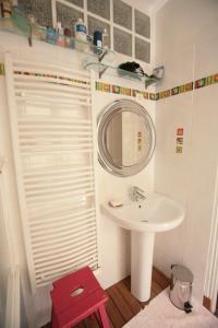 een badkamer met een wastafel, een spiegel en een rode kruk bij Appartement Opéra Paris in Parijs