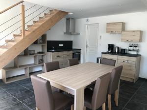 een keuken en eetkamer met een houten tafel en stoelen bij Le Nid du Franc in Avranches