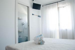 - une chambre blanche avec un lit et une salle de bains dans l'établissement Albergo Medusa, à Punta Marina