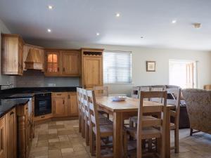 a kitchen with a wooden table and chairs at The Gatehouse at Mullans Bay in Kesh