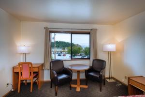 a hotel room with a table and chairs and a window at Cap Sante Inn in Anacortes