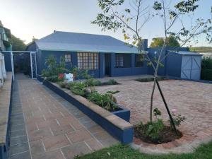 una casa azul con un árbol delante en Green Venus, en Kaapsehoop