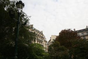 ein Straßenlicht in einer Stadt mit hohen Gebäuden in der Unterkunft Appartement Opéra Paris in Paris