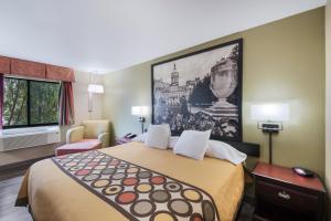 ein Hotelzimmer mit einem Bett mit einem großen Gemälde an der Wand in der Unterkunft Red Carpet Inn-Indian Head in Indian Head