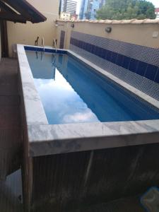 a swimming pool with blue water in a building at Pousada Praia Bela Maceió in Maceió