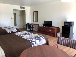 a hotel room with two beds and a desk at The Budget Inn Express in Sheridan