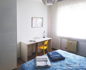 een slaapkamer met een bed, een bureau, een tafel en een stoel bij Appartamento Ivrea Centro - Sito UNESCO in Ivrea