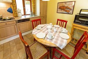 een keuken met een houten tafel met stoelen en een tafel bij Ferienhaussiedlung Strandperlen Buchenhof 4a (Typ IV) in Wustrow