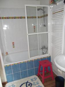 baño con bañera y taburete rojo. en Appartement Opéra Paris en París