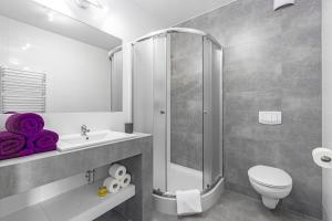 a bathroom with a shower and a toilet and a sink at Wczasowa 8 Apartments in Sarbinowo
