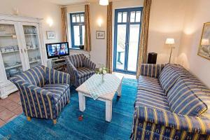 un salon avec deux canapés et une table dans l'établissement Ferienhaussiedlung Strandperlen Weidenhof 8b (Typ V), à Wustrow