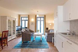 une cuisine et un salon avec un canapé et une table dans l'établissement Ferienhaussiedlung Strandperlen Weidenhof 8b (Typ V), à Wustrow