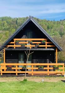 una casa con una valla de madera delante de ella en Eko Domek w górach, en Korbielów