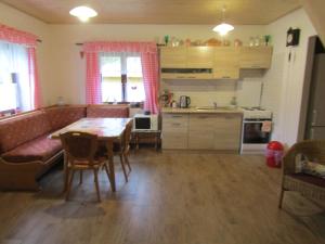 cocina y sala de estar con mesa y sofá en rekreační dům levandule en Jince