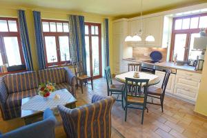 een keuken en een woonkamer met een tafel en stoelen bij Ferienhaussiedlung Strandperlen Sanddornhof 2a (Typ VIII) in Wustrow