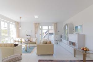 a white living room with white furniture and windows at Haus zum Strand HAUS ZUM STRAND Whg 2.2 in Wustrow