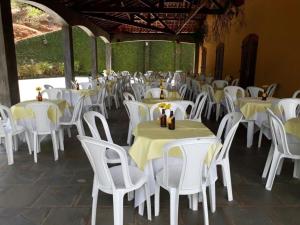a group of tables and chairs with yellow and white tables at Fazenda Carpas Douradas in São Roque