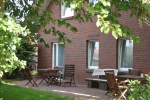 a group of chairs and tables in front of a brick building at Nordsee - Residenz in Dornum