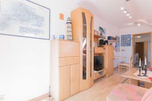 een woonkamer met een grote houten kast en een bureau bij Haus zum Strand HAUS ZUM STRAND Whg 3.4 in Wustrow