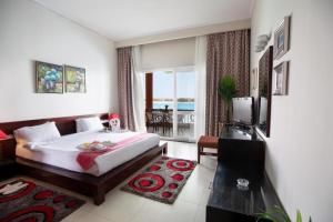 Golden Ocean Marina Hotel في العلمين: غرفه فندقيه بسرير وشرفه