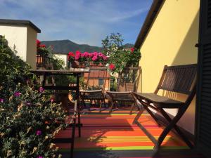eine Terrasse mit Stühlen, einem Tisch und Blumen in der Unterkunft Oasi Hotel in Levanto